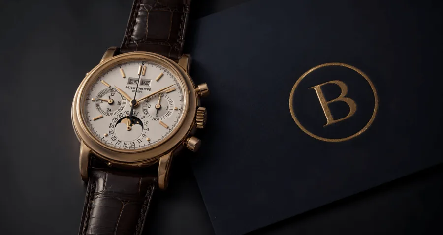 Orologio d'epoca accanto al monogramma dorato Bonanno su fondo scuro